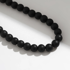 Detail of matte black tiger stone beads showing the smooth frosted texture and uniform round shape
