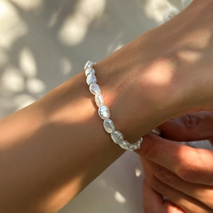 Baroque pearl bracelet for men with irregular pearls on hand under natural sunlight shadows
