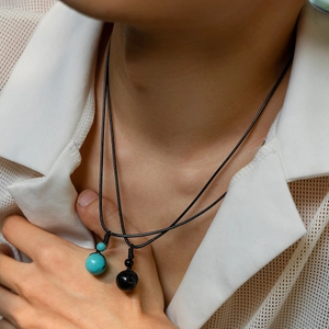Dettaglio della collana minimalista in cordino cerato con perle di turchese e ossidiana nera