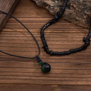 Dettaglio della collana hip hop con perline, ciondolo in pietra verde scuro e cordino
