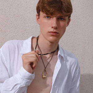Close-up of men's summer necklace set with turquoise beads and golden oval pendant
