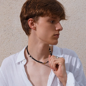 Detail of tiger eye and white turquoise beaded necklace worn with a white linen shirt