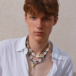 Men's bohemian layered bead necklace featuring shell beads and shark tooth pendant