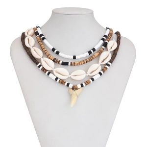Detail of multi-layer bohemian necklace with shells, beads and shark tooth pendant