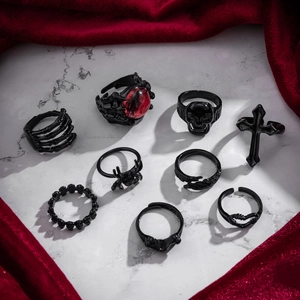 Nine-piece black gothic ring set featuring skull, spider, and cross designs on marble