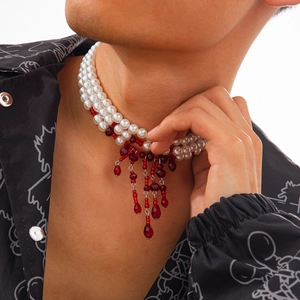 Collier de perles multicouches avec pompons en cristal rouge portés par un homme
