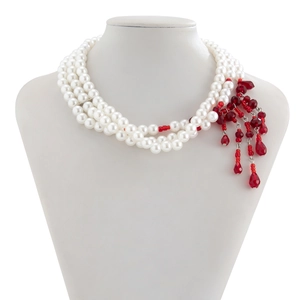 Détail du collier de perles à trois rangs avec accents de glands en cristal rouge