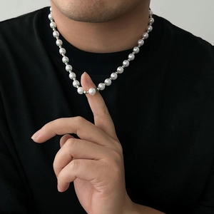 Detail of beaded necklace with white pearls and bright green spacer beads on neck