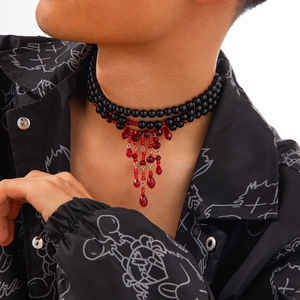 Détail du collier ras de cou à perles noires doubles avec pampilles en cristal rouge