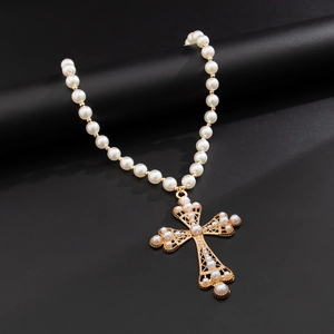 Collier baroque avec pendentif croix dorée et perles sur support noir élégant