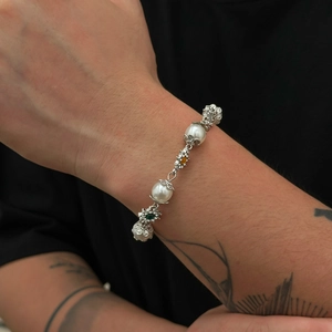 Bracelet de perles rétro avec capsules fleurs argentées et gemmes sur poignet masculin