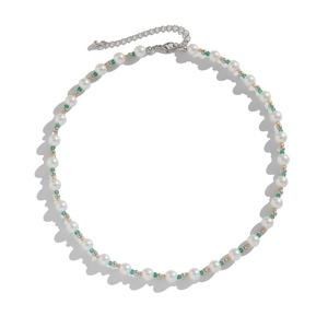 Beaded pearl necklace with green accents and gold spacers on a clean white background