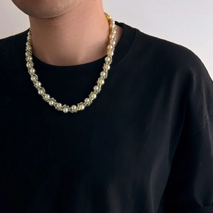 Hip-Hop-Herrenkette mit goldener Kordelkette und Perlen auf schwarzem Hemd