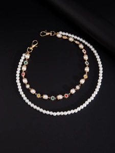 Detail of layered hip-hop trousers chain with white pearls and colorful gemstones charms
