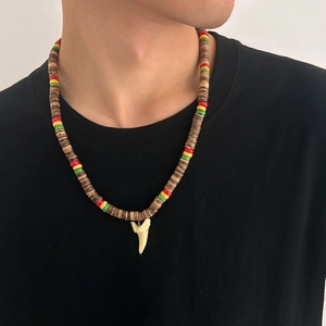 Close-up of a shark tooth pendant necklace with colorful wood beads and coconut shell