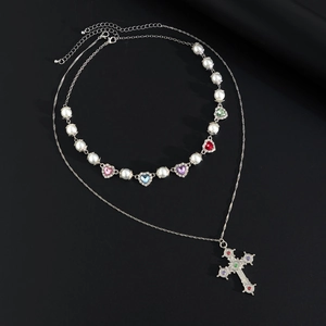 Dettaglio della collana a doppio strato con perle, cuori colorati e pendente a croce