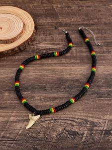 Dettaglio della collana di perline Rasta con pendente a dente di squalo e chiusura a moschettone
