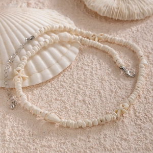Collier de plage pour hommes avec étoiles de mer et coquillages blancs sur du sable