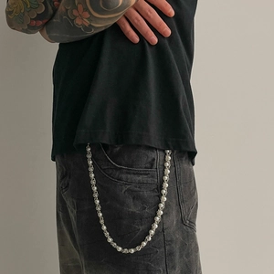 Hip hop pearl and silver metal layered waist chain accessory on denim jeans