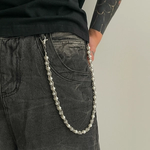 Detail of faux pearl pants chain with metal clips on black denim for hip hop style