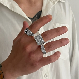 Détails de bagues argentées avec motifs lave et martelé portées par un mannequin