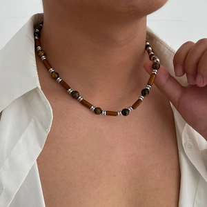 Men's necklace with dark brown wooden beads and tiger eye stones on white linen shirt