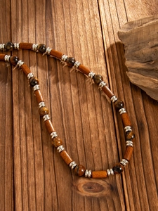 Detail of wooden beads and tiger eye stones on vintage ethnic beaded necklace for men