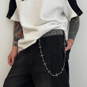 Detailed view of silver cross trouser chain with rhinestones and black rivet leather belt