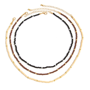 Three-piece set of Bohemian beaded necklaces in black, brown, and cream with gold accents