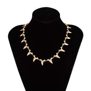 Golden shark tooth charm necklace on a black neck bust with polished metal links