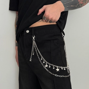 Detail of layered silver star wallet chain with lobster clasps on black trousers