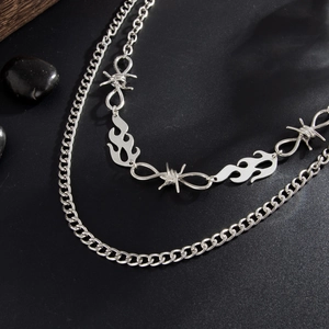 Detail of silver double-layer hip-hop chain with flame pendants and barbed wire design