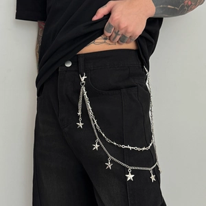 Detail of silver double-layered pants chain with stars and barbed wire link style