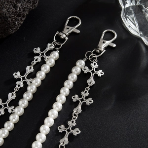 Détail macro de pendentifs croix gothiques et perles brillantes avec fermoirs mousqueton