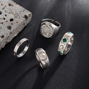 Set of four vintage silver-toned rings for men featuring lion crest and emerald green stones
