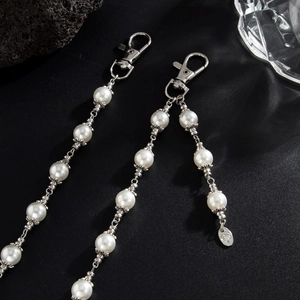 Detail of beaded pearl waist chain with cross pendant and metal lobster clasp