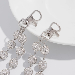 Dettaglio della chiusura a moschettone argento e sfere di strass luccicanti su ceramica