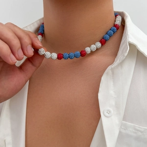 Detail of red white and blue rhinestone beaded necklace for men on a white shirt