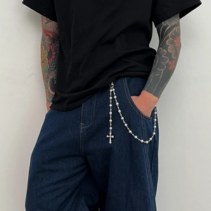 Détail de la chaîne de pantalon hip hop avec perles d'imitation et pendentif croix
