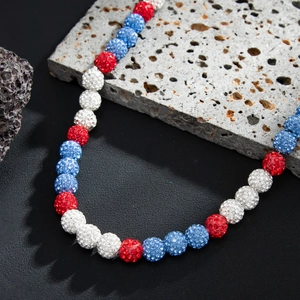 Macro shot of red, white, and blue rhinestone beads on a male beaded necklace