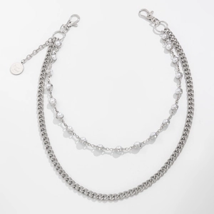 Close-up of double-layer silver chain and pearls with Good Luck tag for jeans