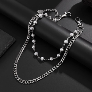 Detail of silver double-layered chain with white pearls and Good Luck heart pendant