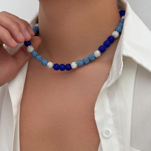 Men's beaded necklace with blue and white sparkling clay beads on a male model