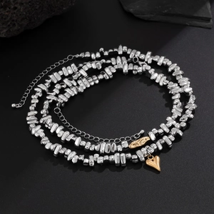 Detailed close-up of silver irregular bead necklace with a gold heart charm and clasp