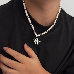 Collier perles pour hommes avec pendentif tournesol argenté sur t-shirt noir