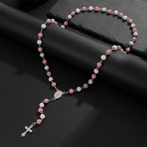 Dettaglio del rosario con perle di cristallo rosa e bianche, croce d'argento e medaglia sacra