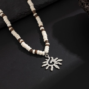 Gros plan du pendentif tournesol sur un collier de perles tribal avec accents en bois