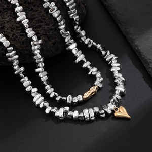 Detailed shot of beaded CCB necklace with irregular silver pieces and golden heart charms