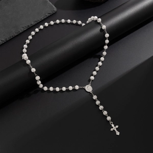 Dettaglio di collana rosario argento con perle di cristallo e croce su pietra nera