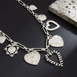 Dettaglio di ciondoli a cuore in argento su una catena per pantaloni a maglie pesanti